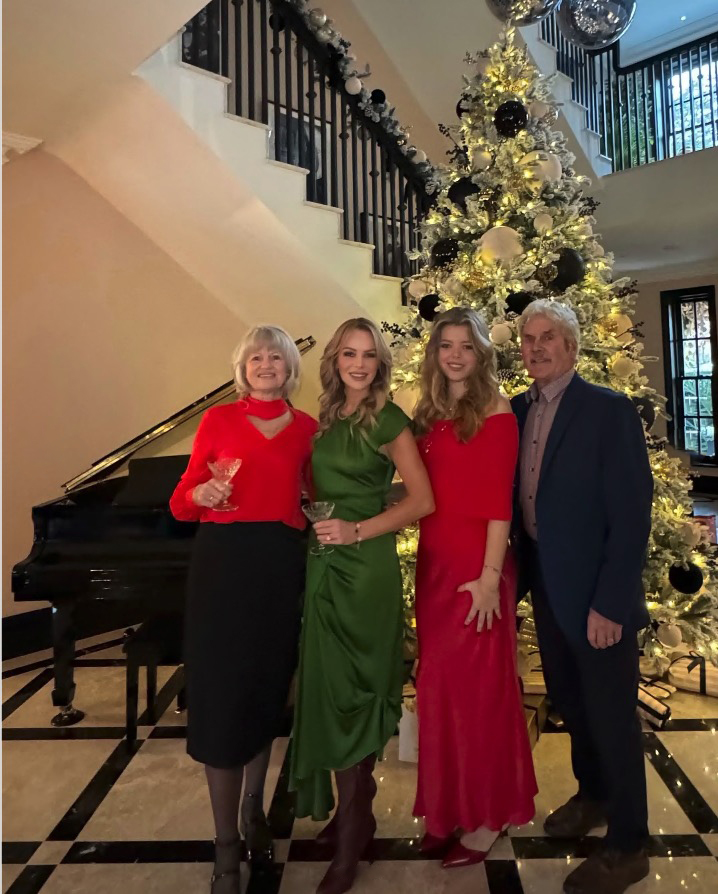 Family posing by a Christmas tree.