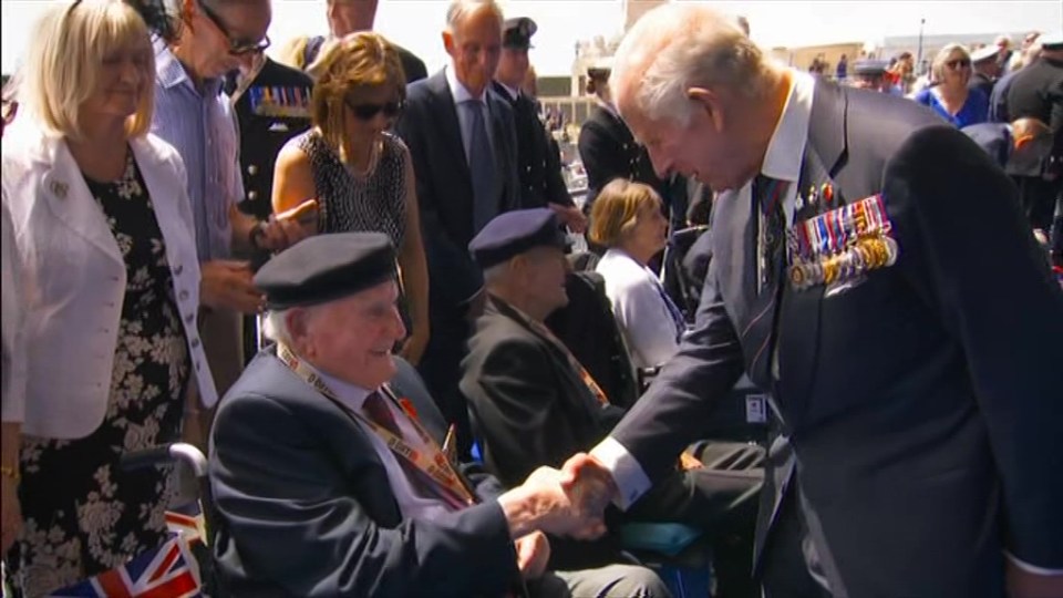 King Charles III shaking hands with a veteran.