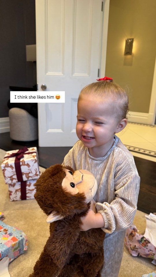 Toddler hugging a stuffed monkey.