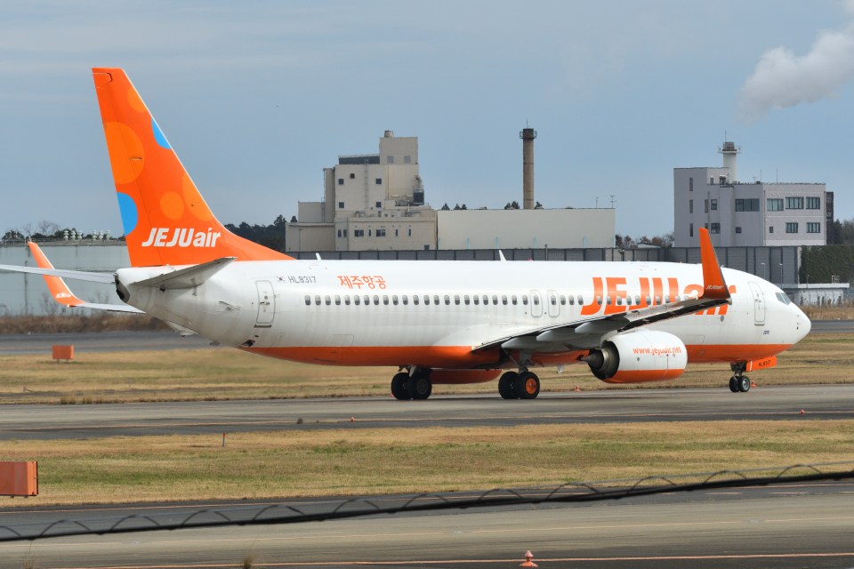 Jeju Air Boeing 737-800 taxiing on airport runway.