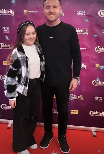 Man and girl posing at Cinderella event.