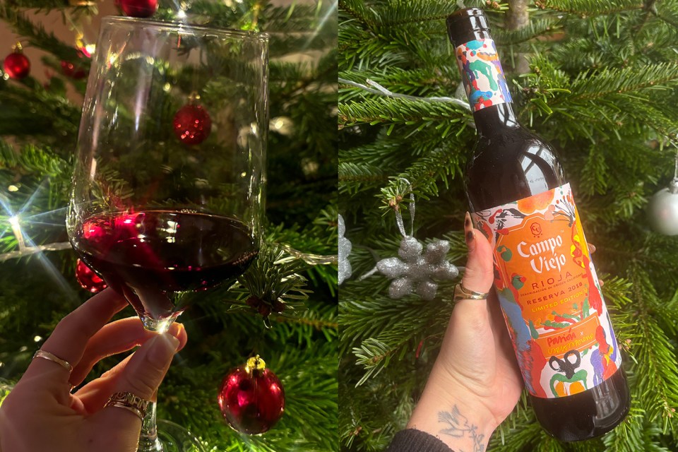 A glass of red wine and a bottle of Campo Viejo Rioja Reserva 2018 in front of a Christmas tree.