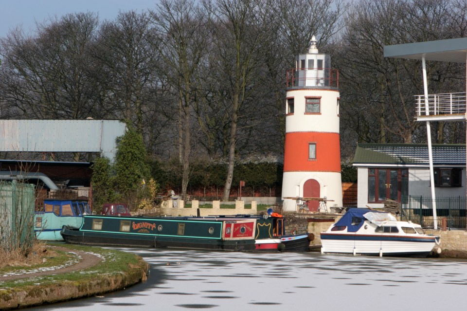 Lighthouse on Bridgewater Canal with boats and ice.