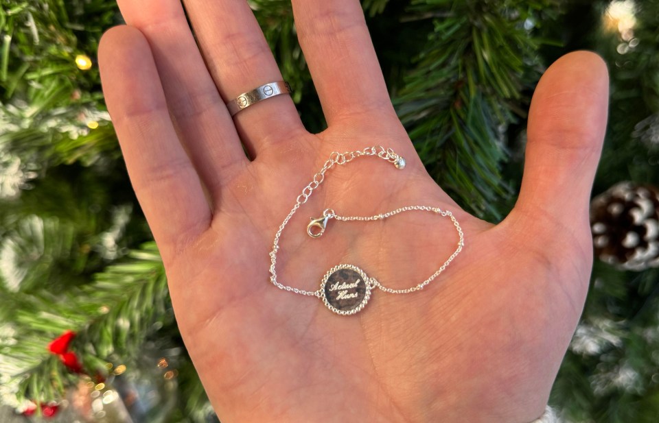 Silver bracelet with "Actual Humans" inscribed on a circular charm.