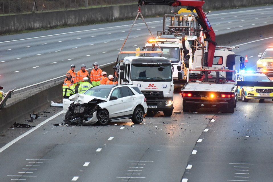 Three-vehicle motorway accident with emergency responders and recovery vehicles.