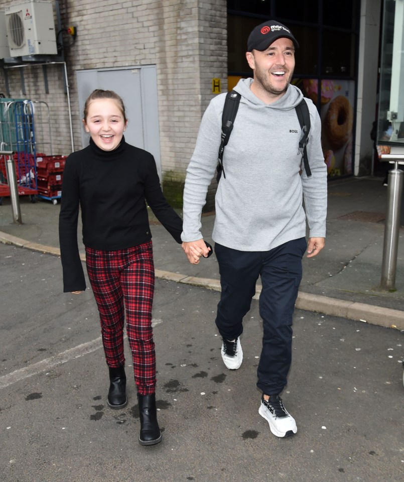 Alan Halsall and his daughter Sienna holding hands at an airport.