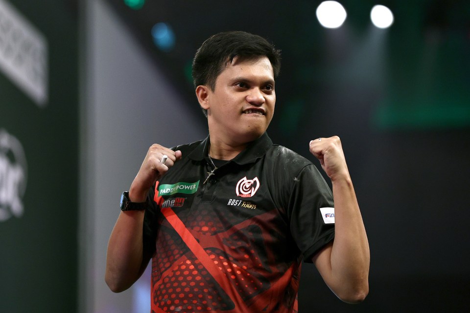 Alexis Toylo of the Philippines celebrates during a darts match.