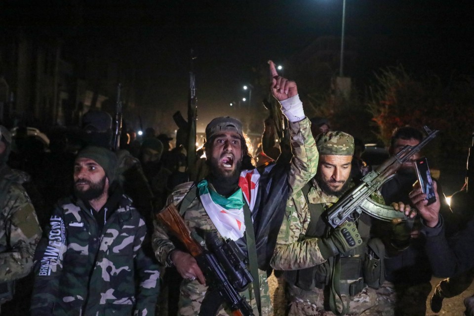 Islamist-led Syrian rebel fighters celebrate in the streets of Homs in the early hours of Sunday after entering Syria's third city overnight