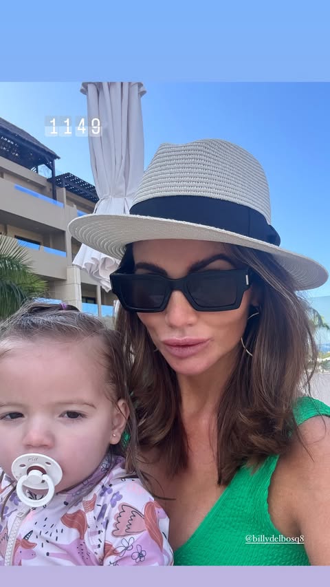 Amy Childs in a green swimsuit with her daughter.