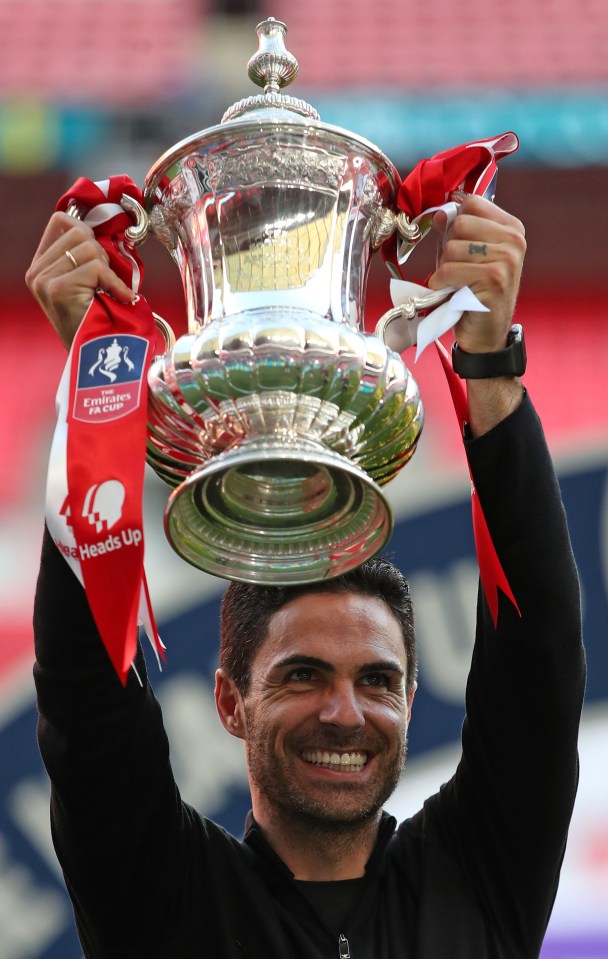 Mikel Arteta holding the Emirates FA Cup trophy.