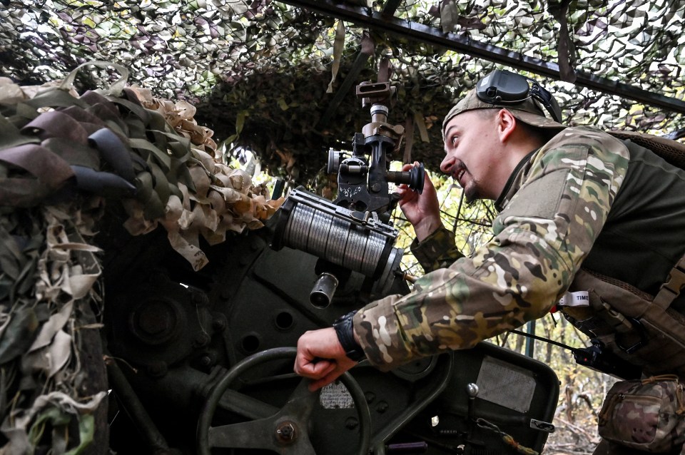 A Ukrainian artilleryman of the Khyzhak Patrol Police Special Unit aims a howitzer during combat in the Donetsk region, eastern Ukraine