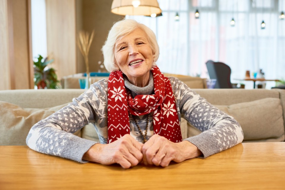 Smiling senior woman wearing a Christmas scarf.