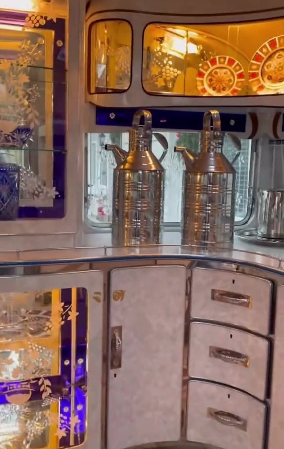 Interior of a luxury caravan showing cabinets filled with china and other decorative items.