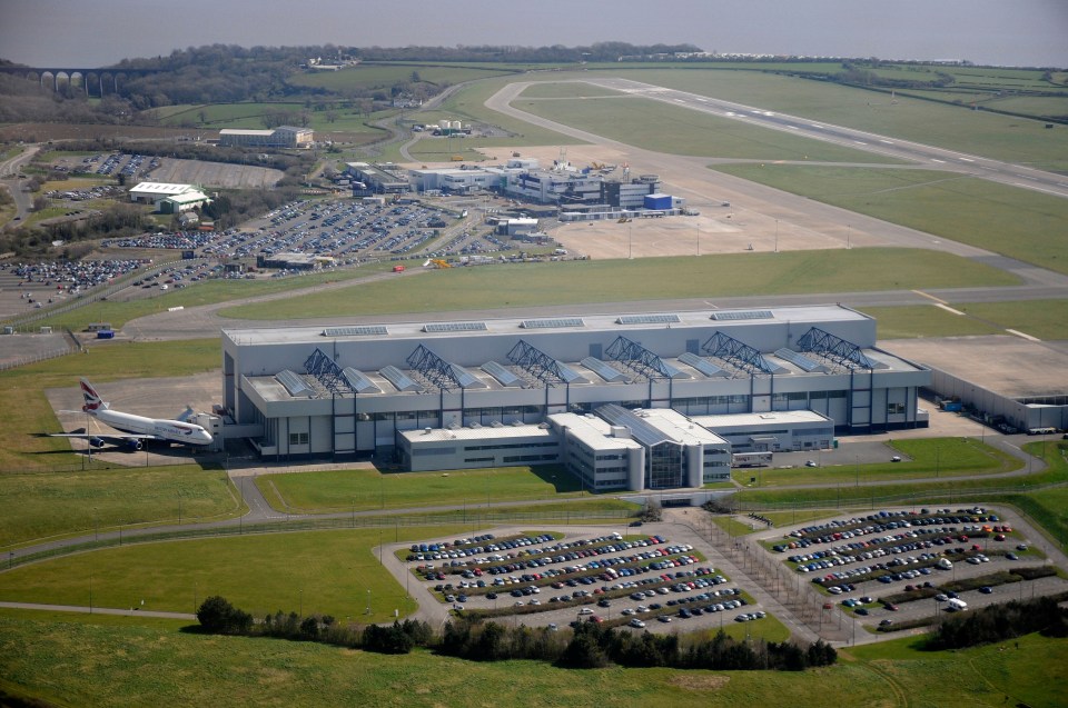 Aerial view of Cardiff International Airport, showing the terminal building, runways, and a large aircraft parked near a hangar.