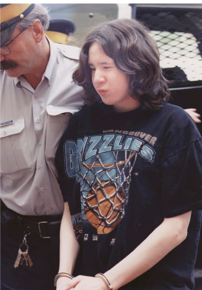 A handcuffed 14-year-old boy is led into court.