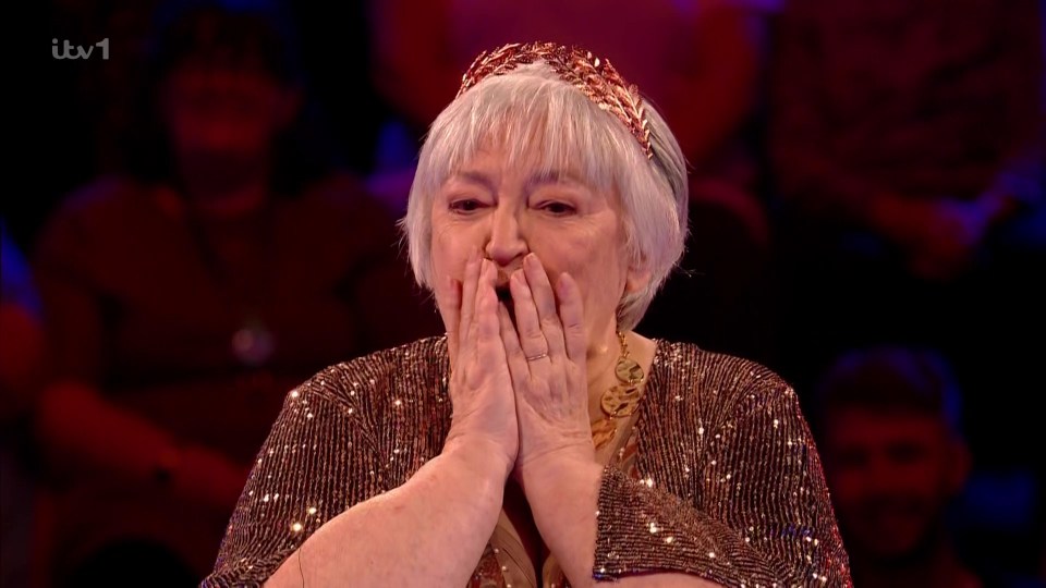 A shocked woman in a sparkly top wins a large sum of money on Beat the Chasers.