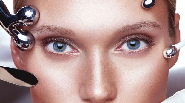 Close-up of a woman's face receiving a beauty treatment with facial rollers.