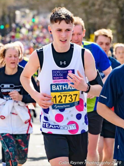 Runner in a polka dot vest participating in a marathon.