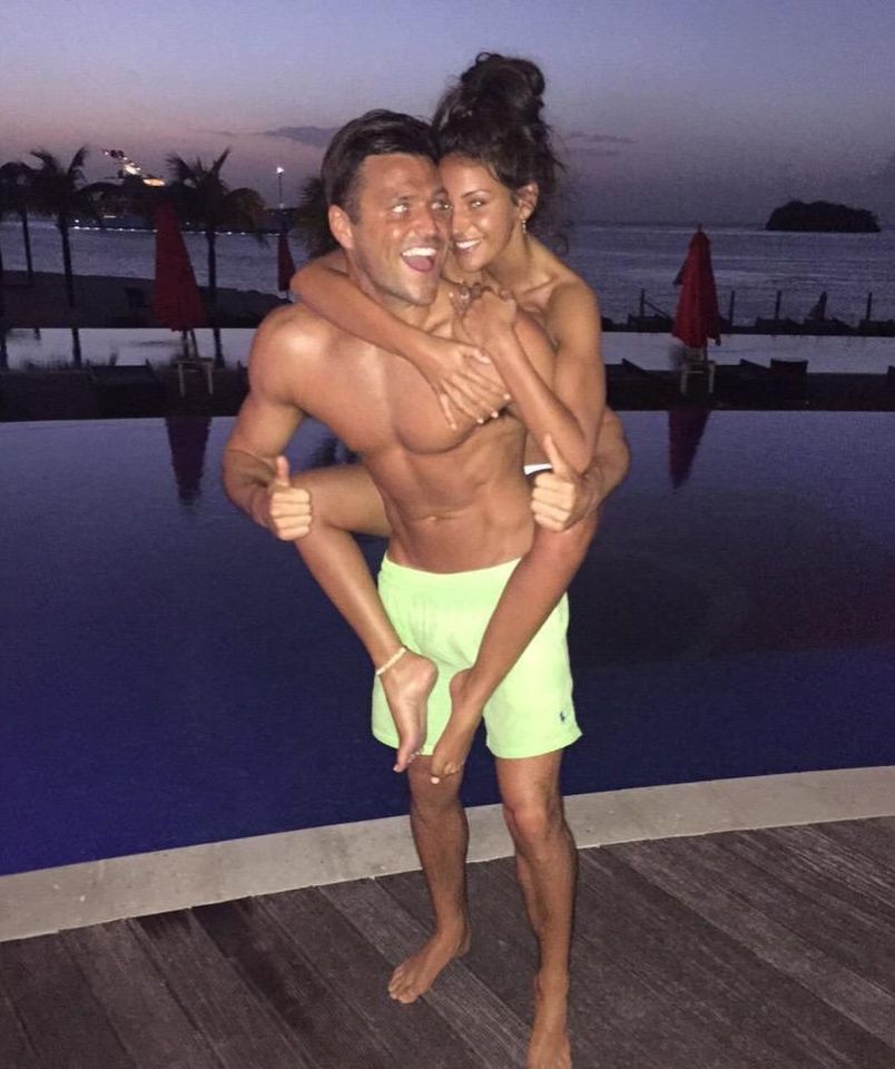 Mark Wright giving Michelle Keegan a piggyback by a pool.