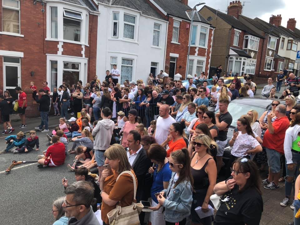 A large crowd of people gathered on a residential street.