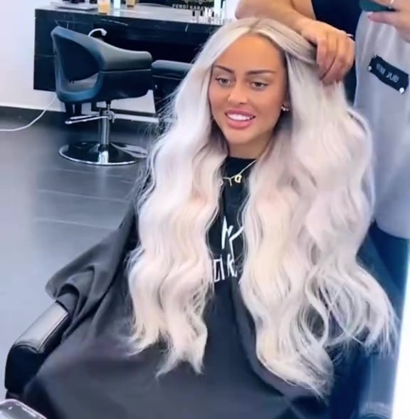 Woman getting her long blonde hair styled in a salon.