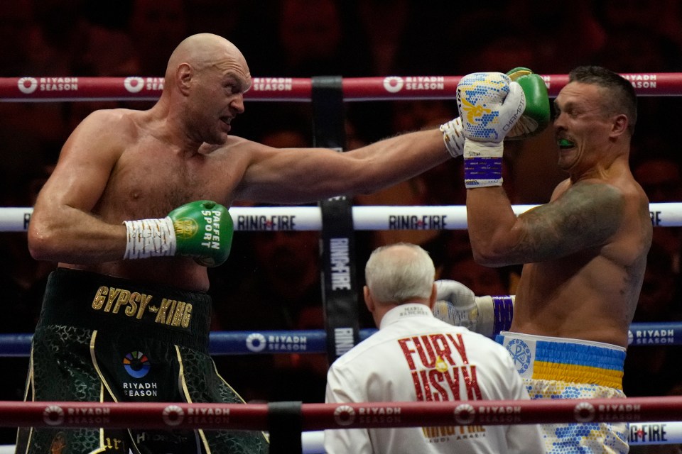 Tyson Fury punches Oleksandr Usyk in a boxing match.