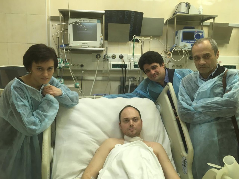 Vladimir Kara-Murza in a hospital bed with three visitors.