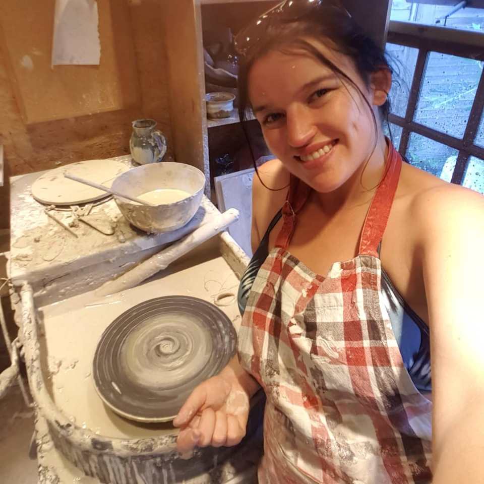 Woman at a pottery wheel.