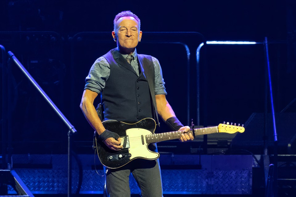 Bruce Springsteen playing guitar on stage.