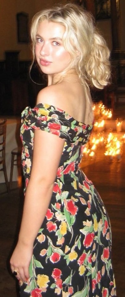 Woman in floral dress at candlelit event.