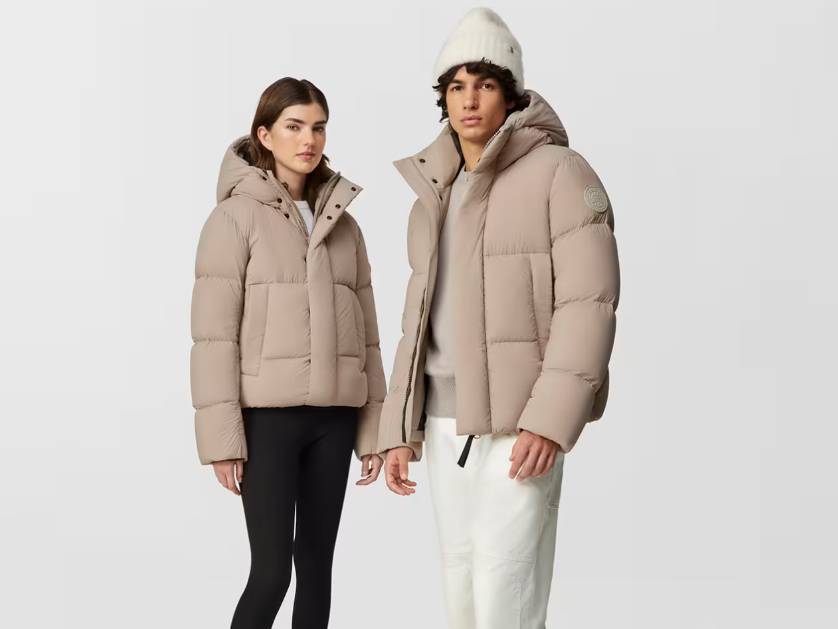 Beige Canada Goose puffer jackets on a man and woman.