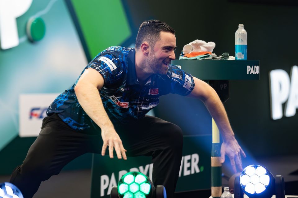 Luke Humphries celebrates winning his second-round darts match.