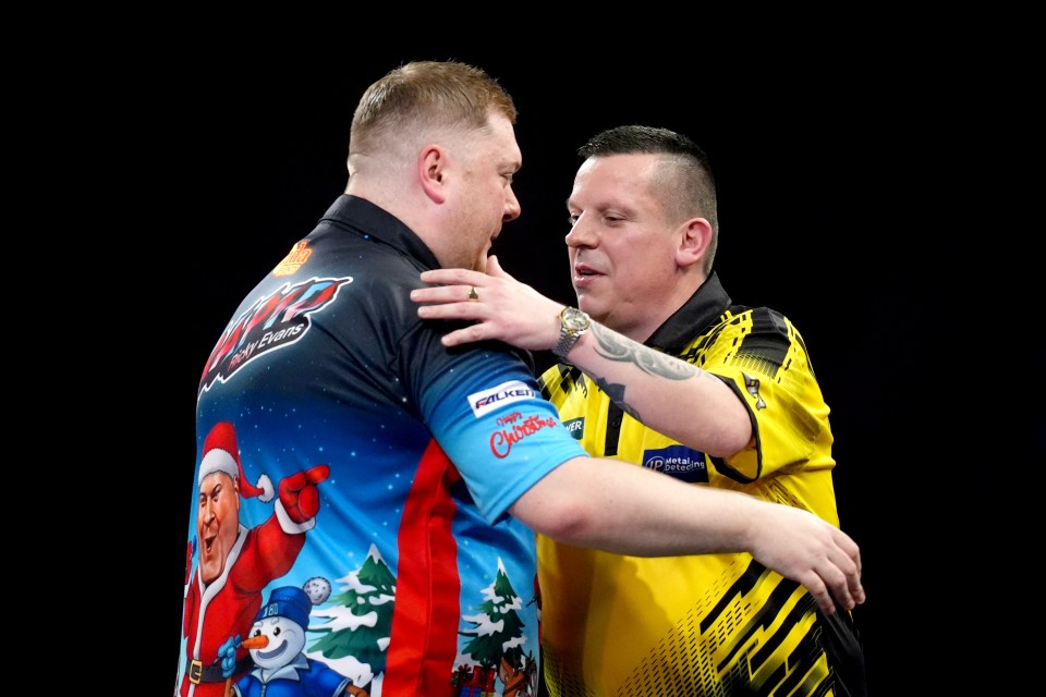 Ricky Evans is congratulated by Dave Chisnall after a darts victory.