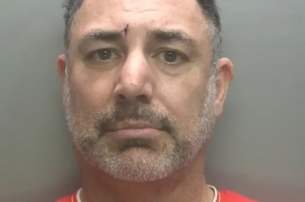 Mugshot of a man with graying hair and a red shirt.