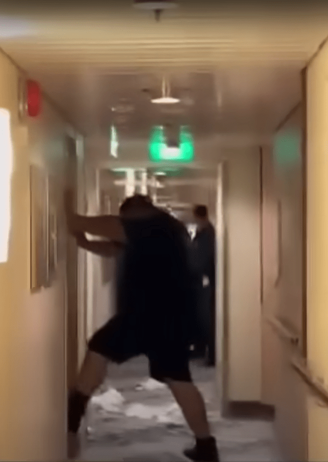 A passenger violently pushing against a wall on a cruise ship.