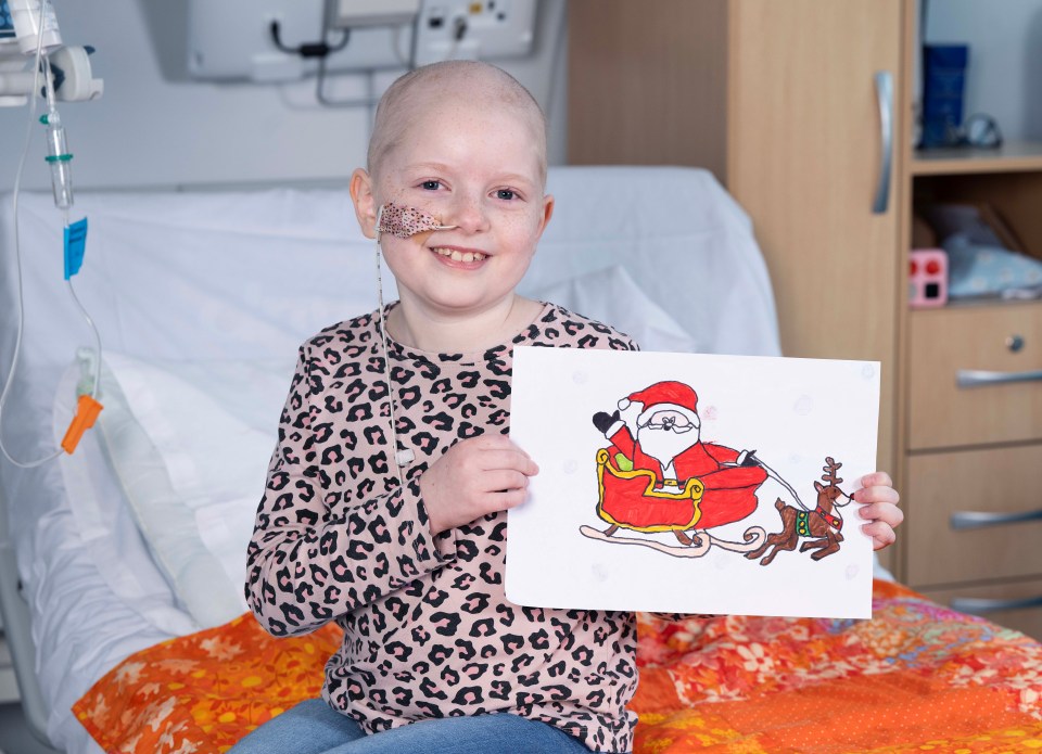 A young girl in a hospital bed proudly displays her winning Christmas drawing of Santa Claus in a sleigh pulled by a reindeer.