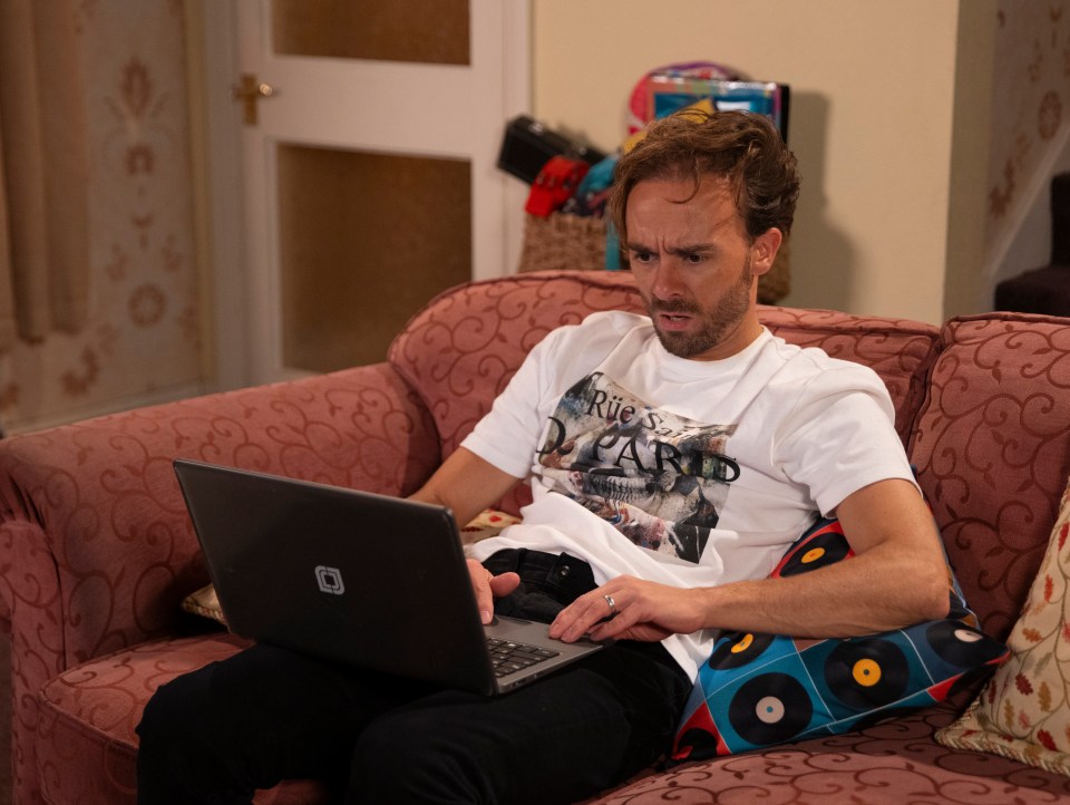 David Platt on a sofa using a laptop.