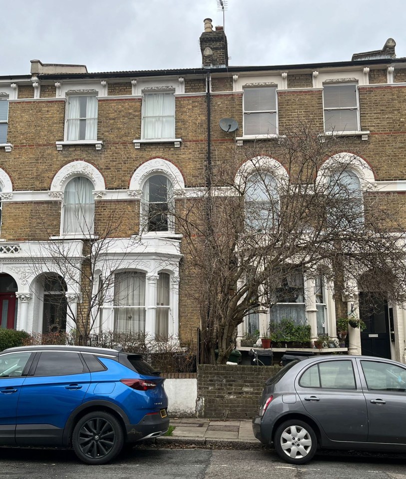 Two houses with dark doors, a blue car parked in front of one, and a silver car in front of the other.