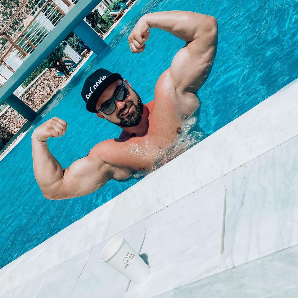 Bodybuilder Karol Olender flexing in a swimming pool.