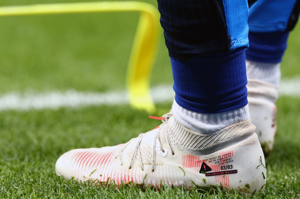 Close-up of Marc Cucurella's soccer boots on the field.