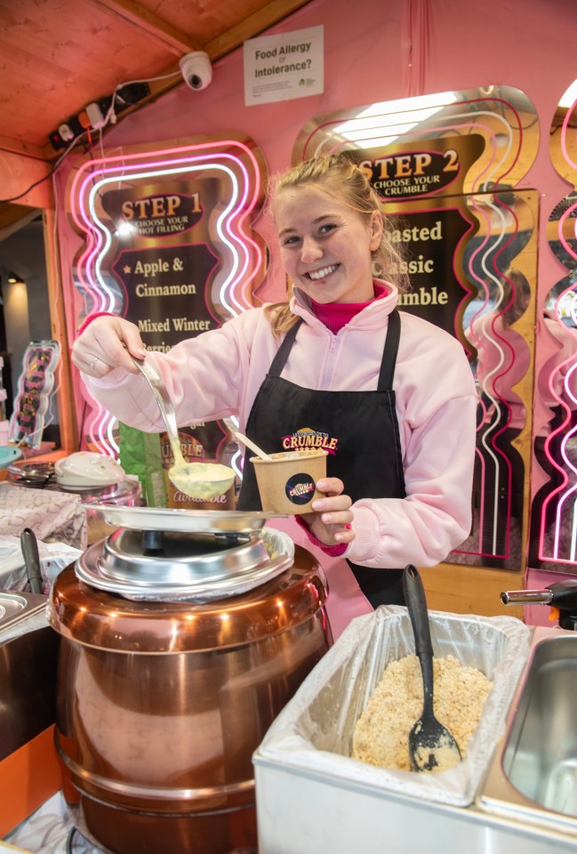 Woman serving crumble at a Christmas market.