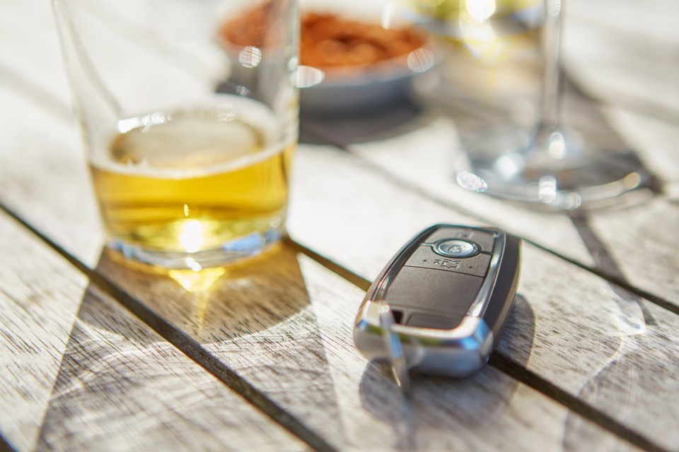 Car key and beer on a table; don't drink and drive.