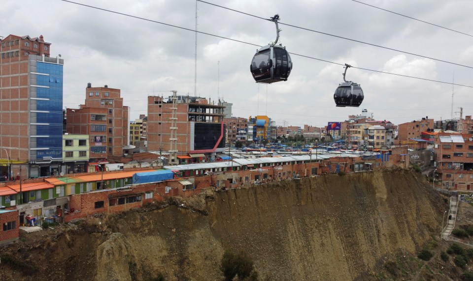 A cable car cabins pass over a row of houses