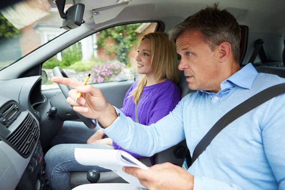 Driving instructor giving a teenage girl a driving lesson.