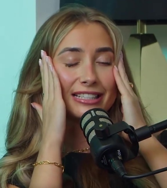 Woman reacting in disbelief while speaking into a microphone.