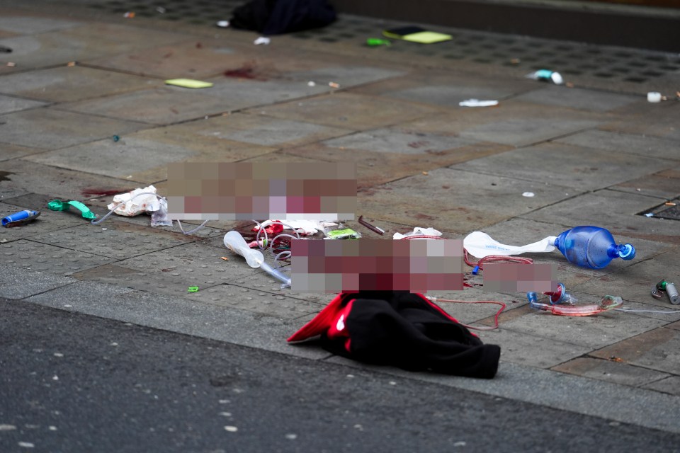 Crime scene on Shaftesbury Avenue showing blood and medical equipment on the pavement.