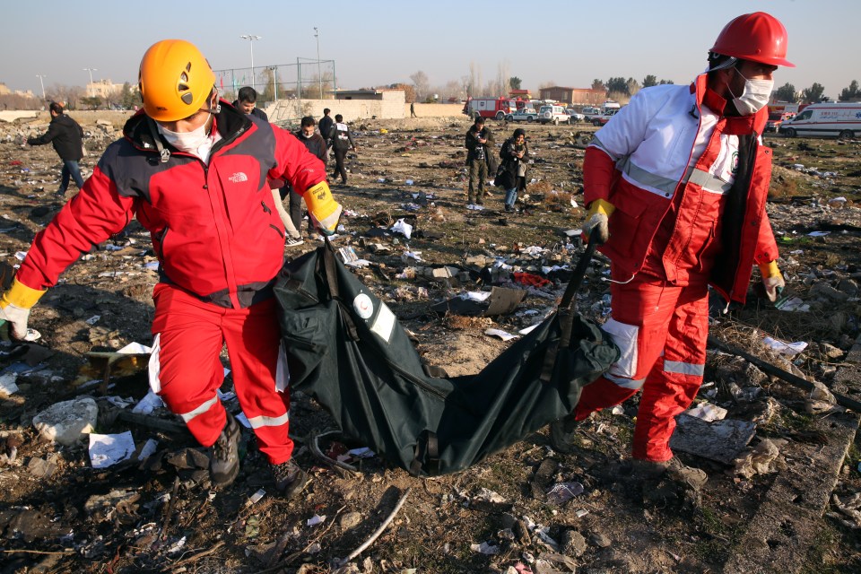 Members of the International Red Crescent collect dead bodies after a Ukraine International Airlines Boeing 737-800 was shot down in 2020