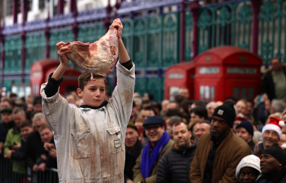 A young meat trader holds a piece of meat aloft at a Christmas Eve auction.