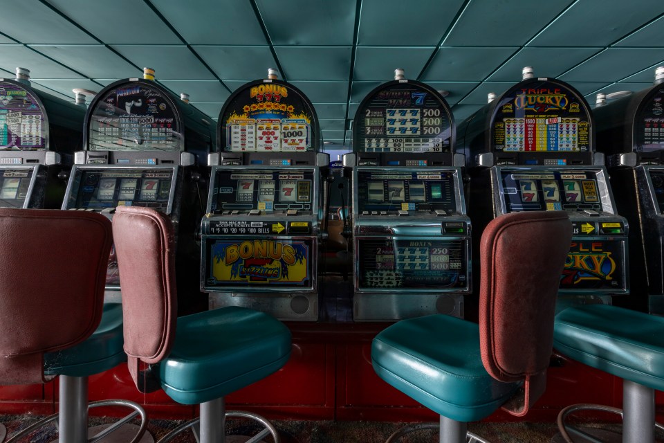 Slot machines and chairs in an abandoned casino.