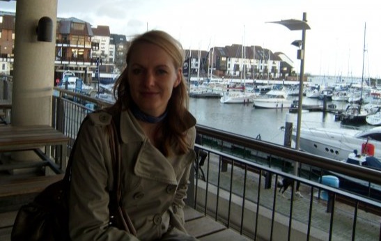 Woman sitting outside at a marina bar.